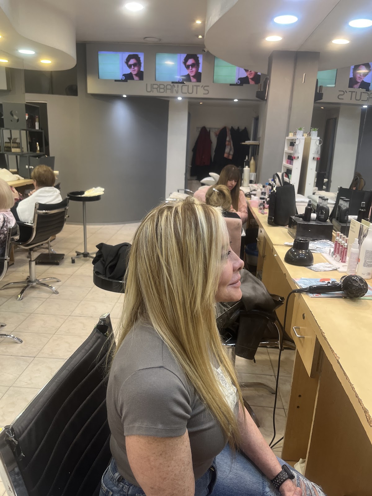 Clienta con reflejos rubios recién hechos en el salón